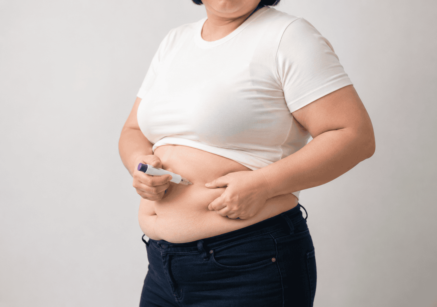 비만인 사람이 주사펜으로 배에 약물을 자가 주사한다.