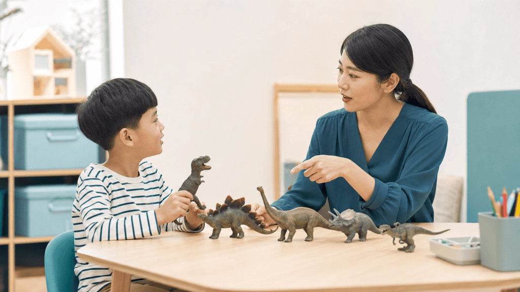 공룡 피규어를 사이에 두고 대화 순서를 연습하는 만 5세 아이와 언어치료사