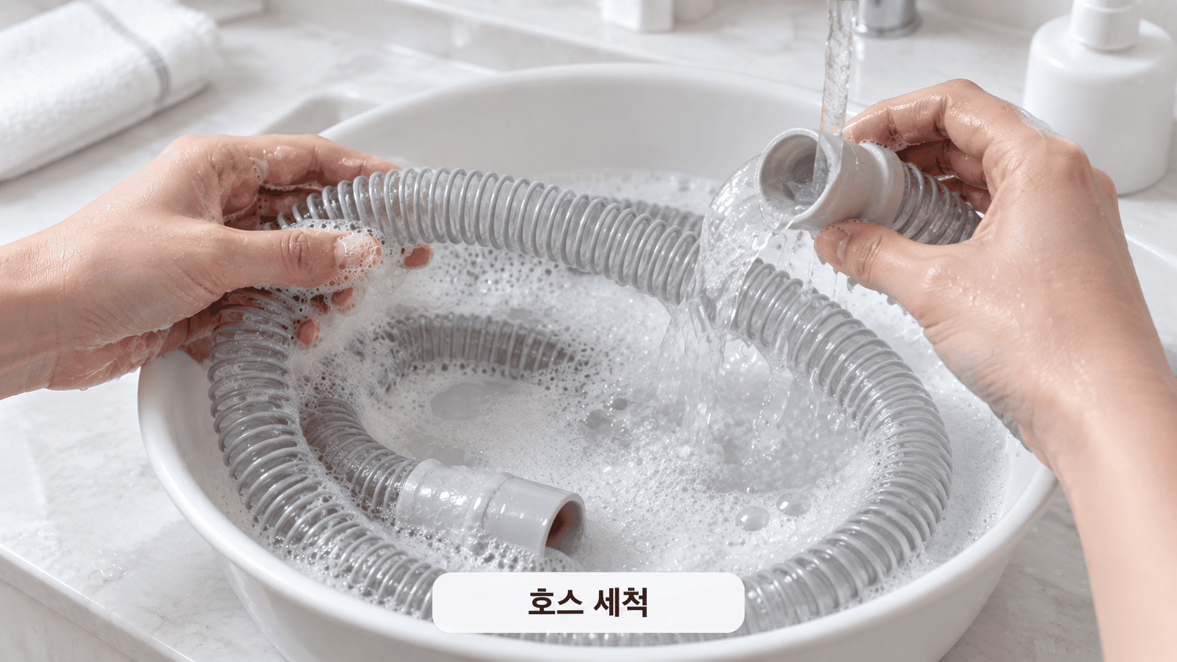 손으로 양압기 호스를 비눗물에 넣어 수돗물로 세척 중